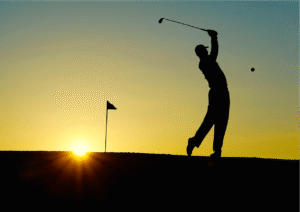 Silhouette of a golfer swinging at sunrise, capturing the essence of the sport.